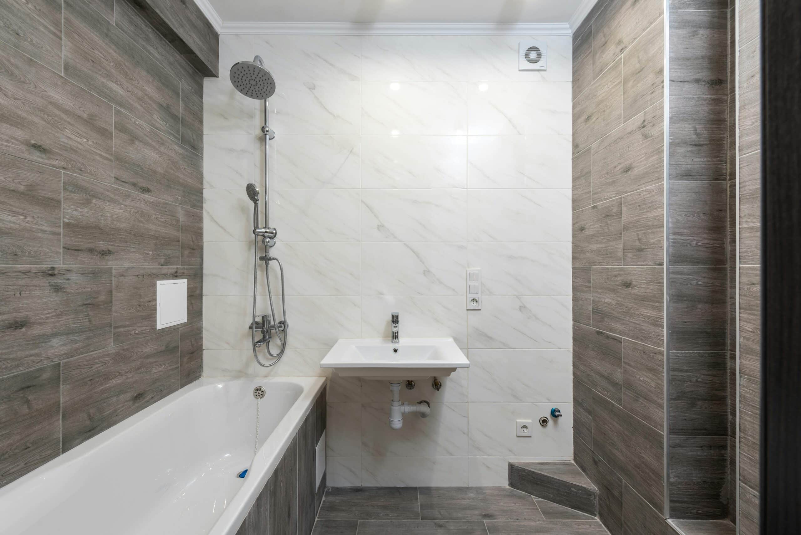 Salle de Bain Moderne avec Carrelage Gris et Marbre Blanc Elegant modern bathroom interior with wooden details and sleek design.